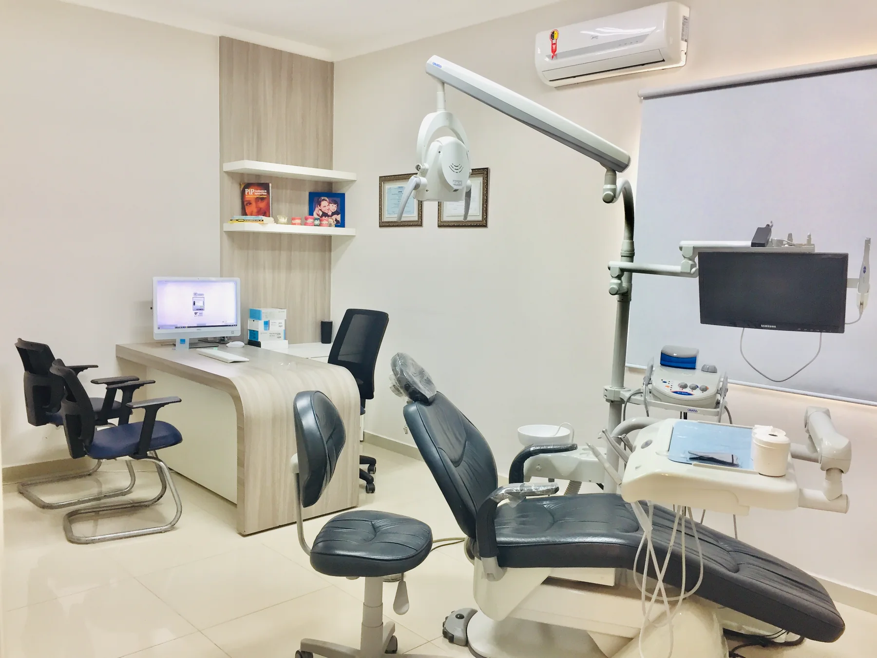 Consultório da Pinhatari Odontologia, com cadeira odontológica, refletor e monitor